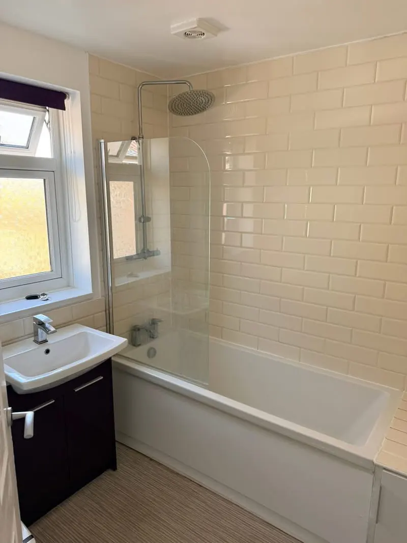 Bathroom before, with a purple vanity unit, cream tiles and a striped vinyl floor