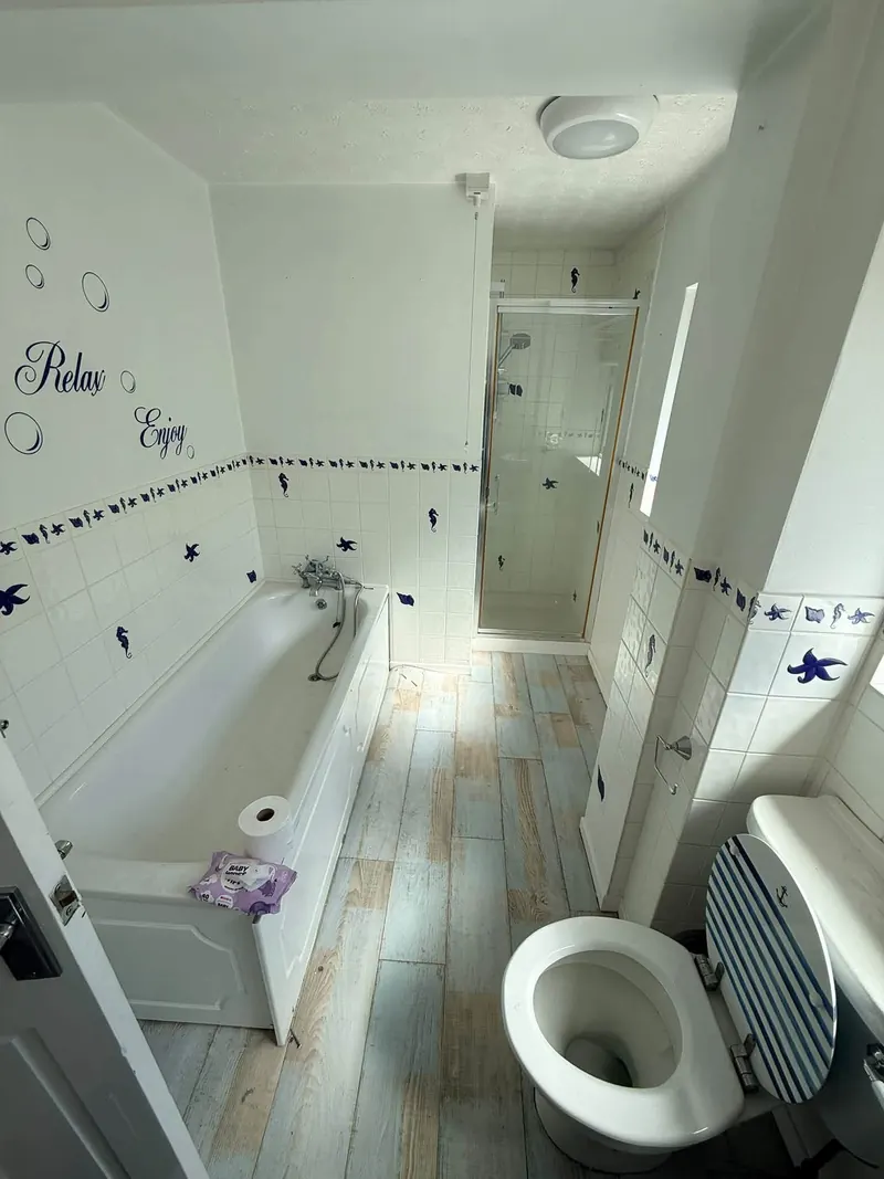 Bathroom before, with seahorse and starfish tiles, a bath and a separate shower cubicle
