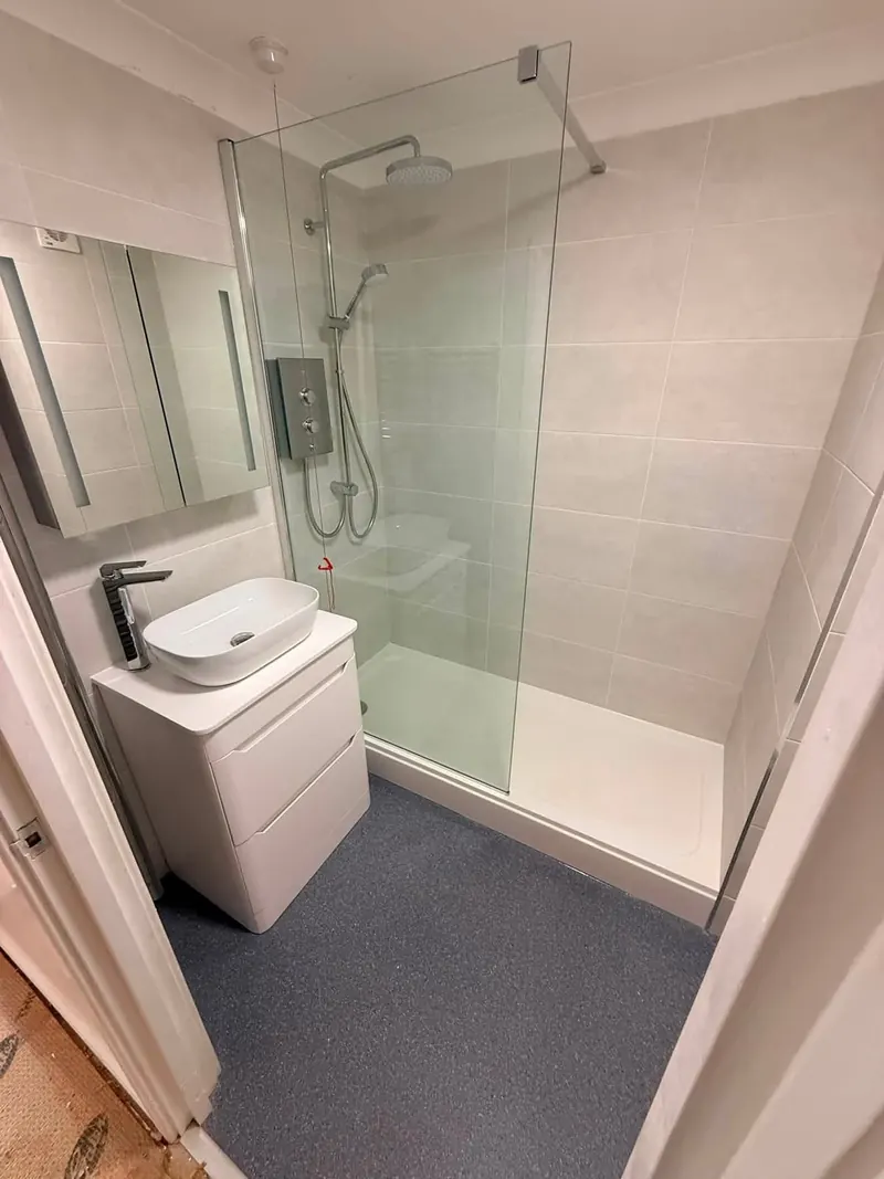 New shower room with a walk-in shower, light grey tiles and a white vanity unit with a countertop basin