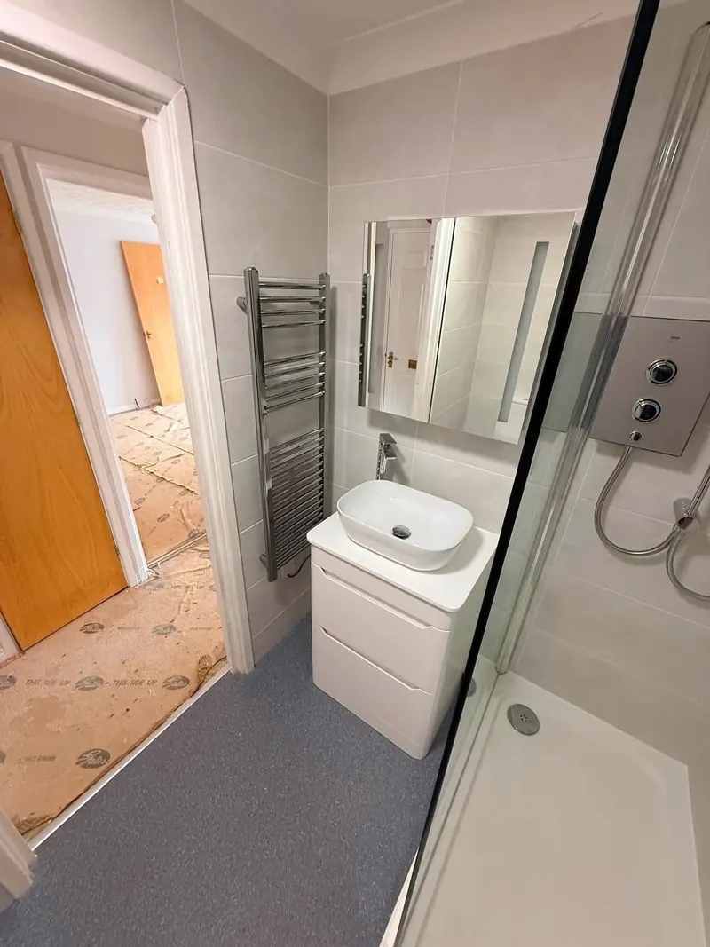 White vanity unit with a countertop basin, an LED mirror and a chrome towel rail
