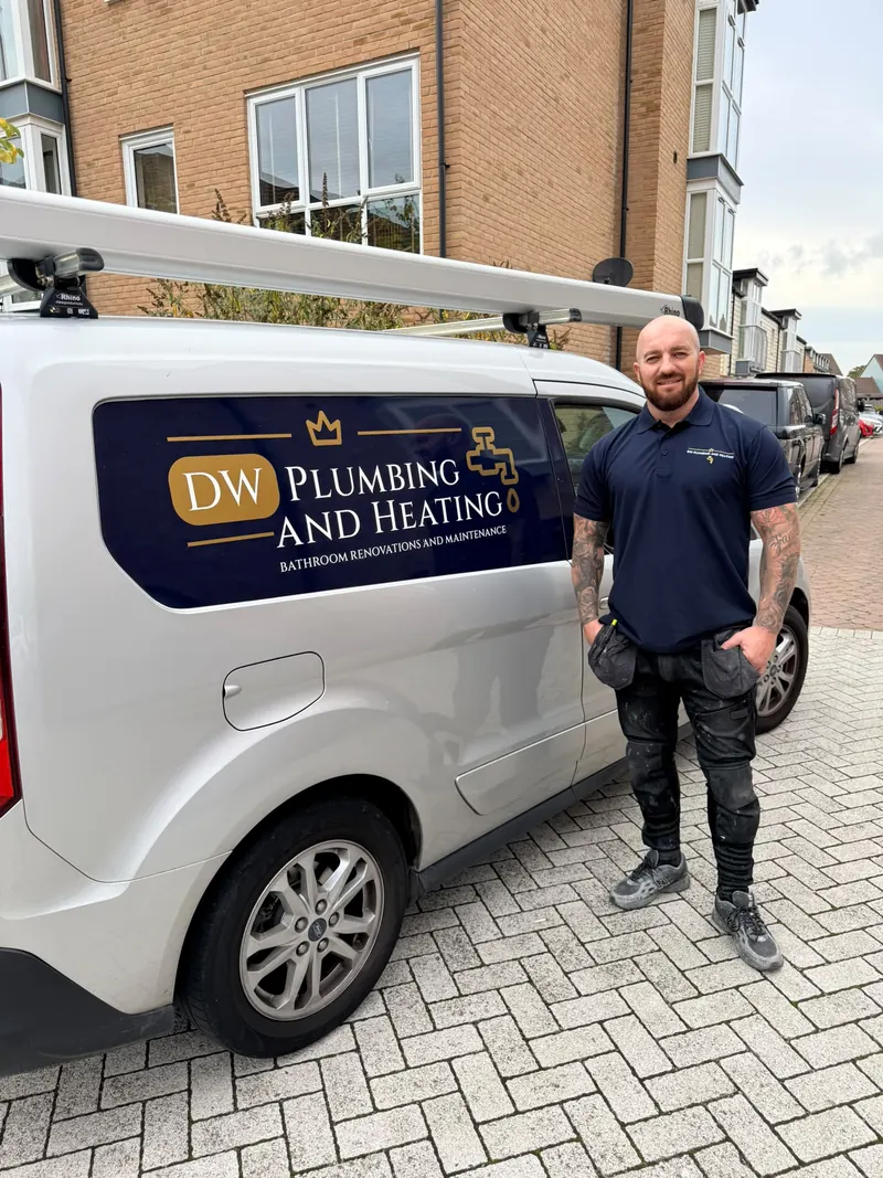 Dean Western in his DW Plumbing and Heating polo shirt, standing next to his van with the logo on the side