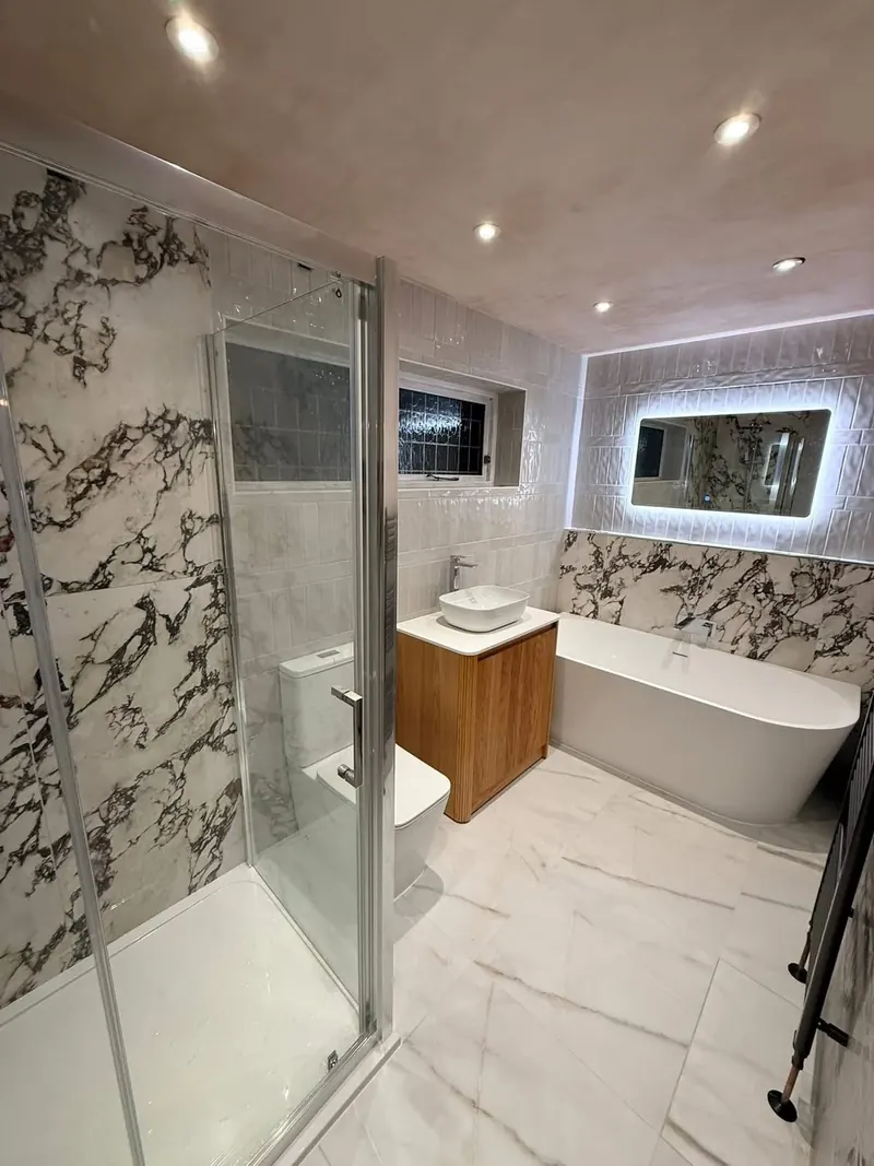 Shower enclosure, vanity unit and back-to-wall bath under recessed lights