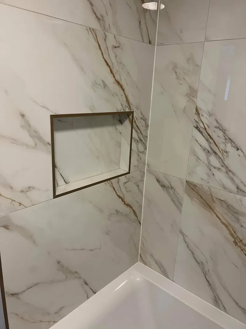 Niche for toiletries in the shower wall, with a bronze-coloured trim