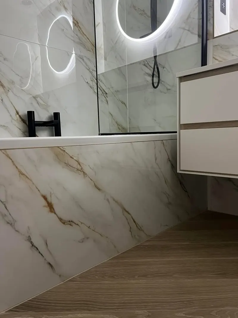Tiled bath panel and a herringbone wood-effect floor